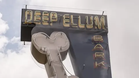 Neon dog-bone sign at the Deep Ellum bark park in Dallas
